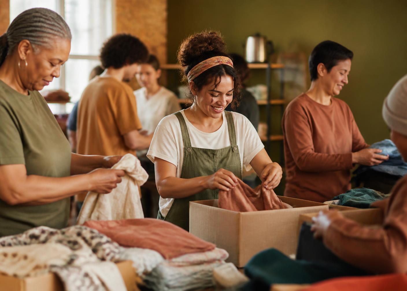 Community volunteers sorting donated clothing and packing boxes together
